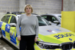 Lisa stands next to a police car